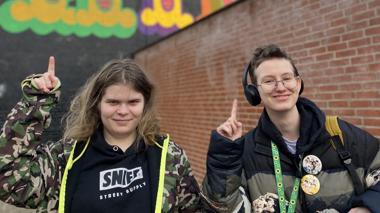To unge mennesker står foran grafitti-væg